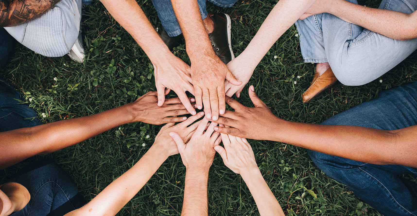 Many people holding their hands together